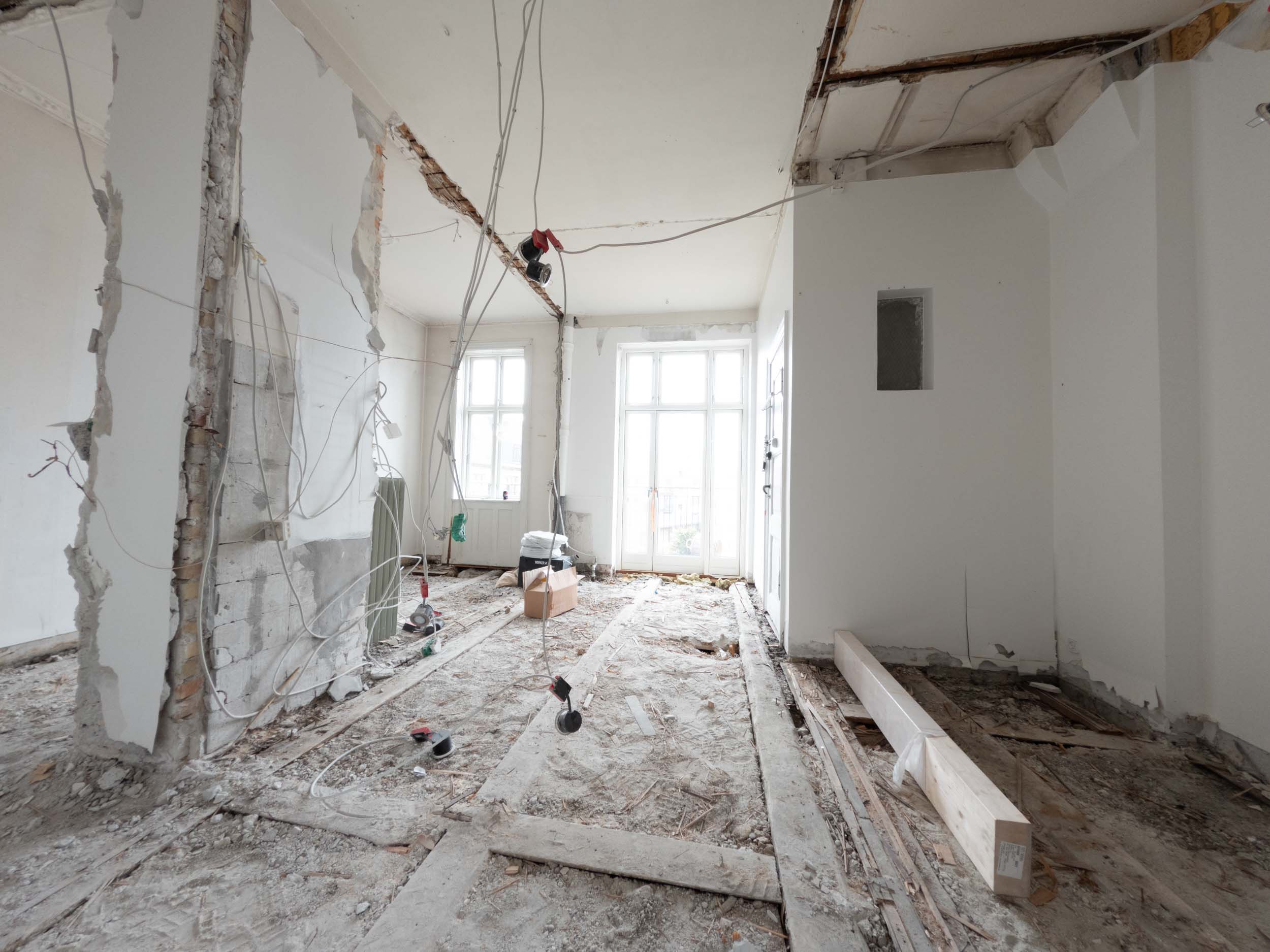 Køkken og spiseplads tidligt under arbejdet med åbent gulv og synlige installationer