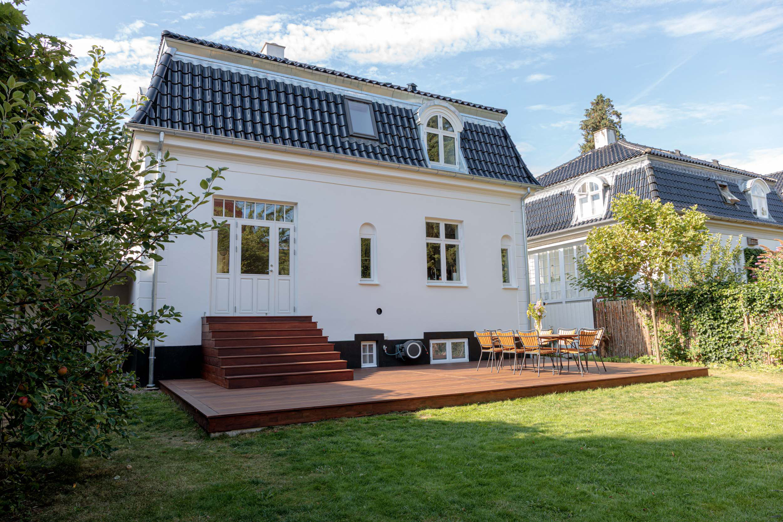 Villaens havefacade med bred træterrasse